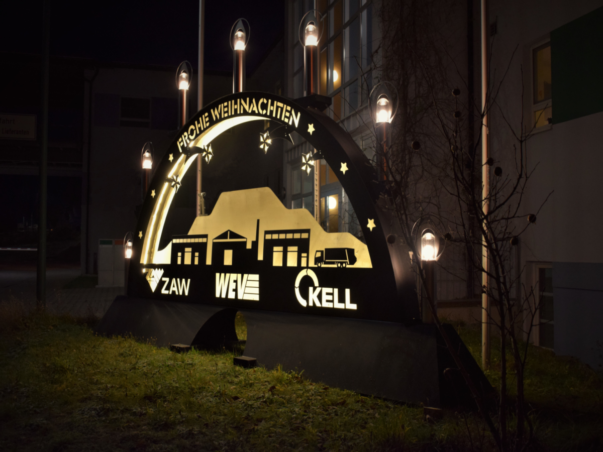 Ein großer Schwippbogen vor einem Gebäude im Dunkeln.