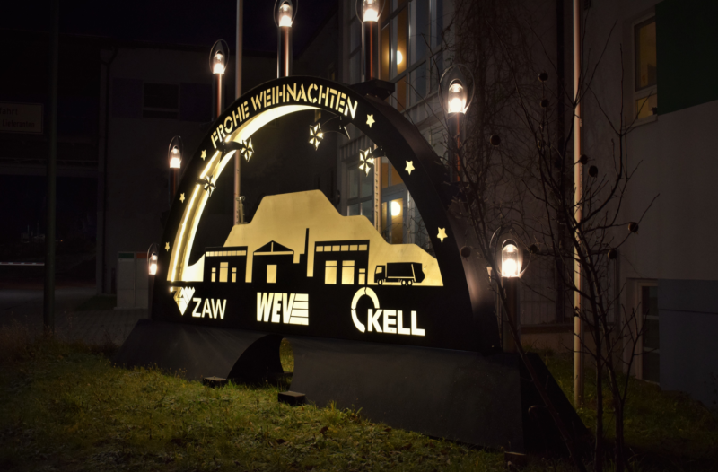 Ein großer Schwippbogen vor einem Gebäude im Dunkeln.